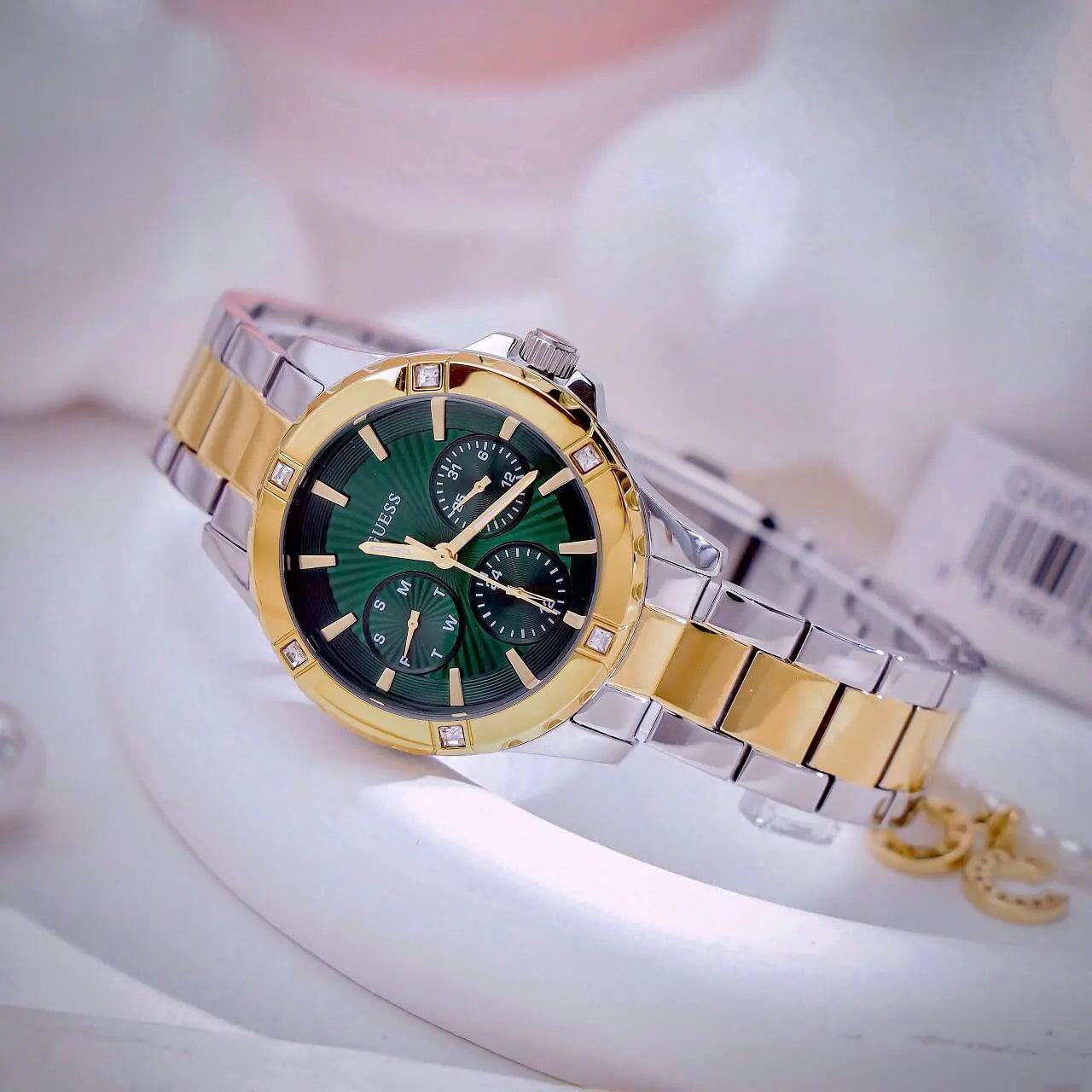 Guess Mist watch worn on wrist displaying green dial and chronograph subdials