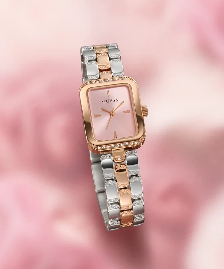 GUESS GW0865L5 rose gold and silver watch worn on wrist with pink blurred background