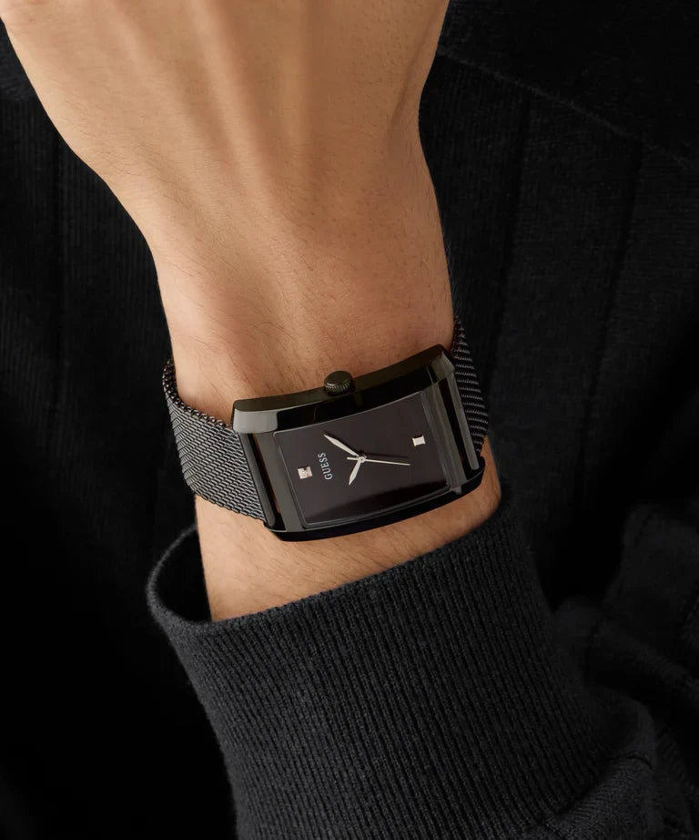 GUESS GW0898G3 black watch on wrist with black mesh band and dark sleeve