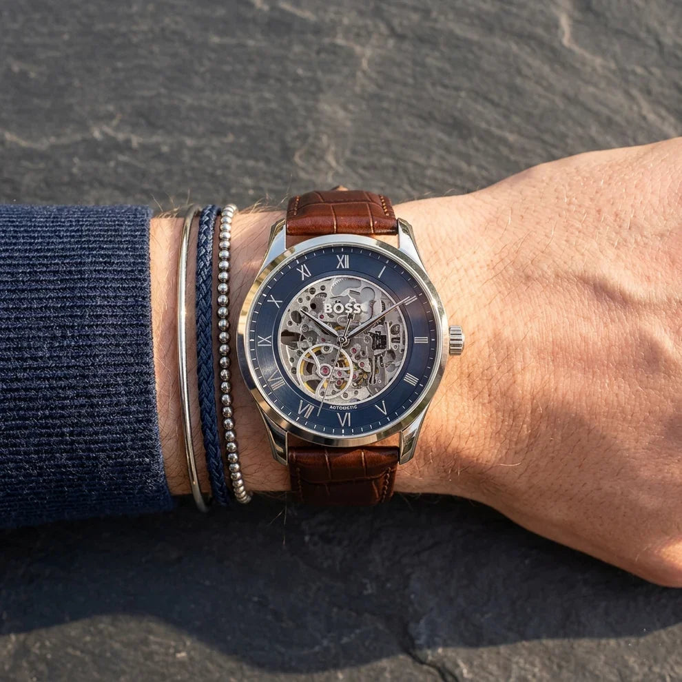 Hugo Boss skeleton watch on wrist showing navy dial with exposed automatic movement
