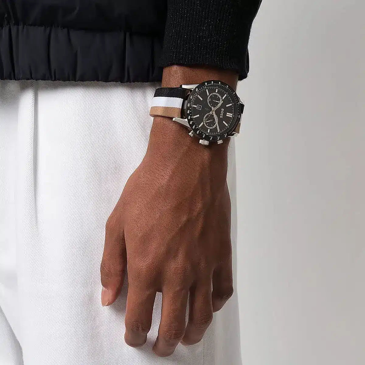 Hugo Boss Allure chronograph watch on wrist displaying black dial, tachymeter scale, and striped strap