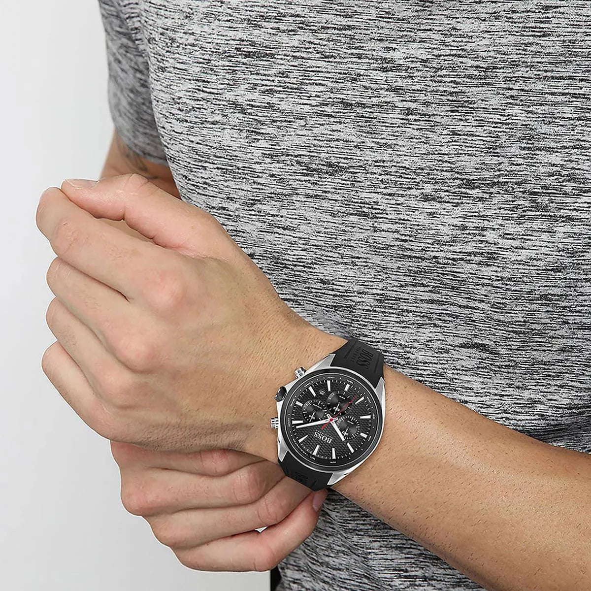 Hugo Boss Distinct chronograph watch worn on wrist showing black dial and black rubber strap against grey sleeve