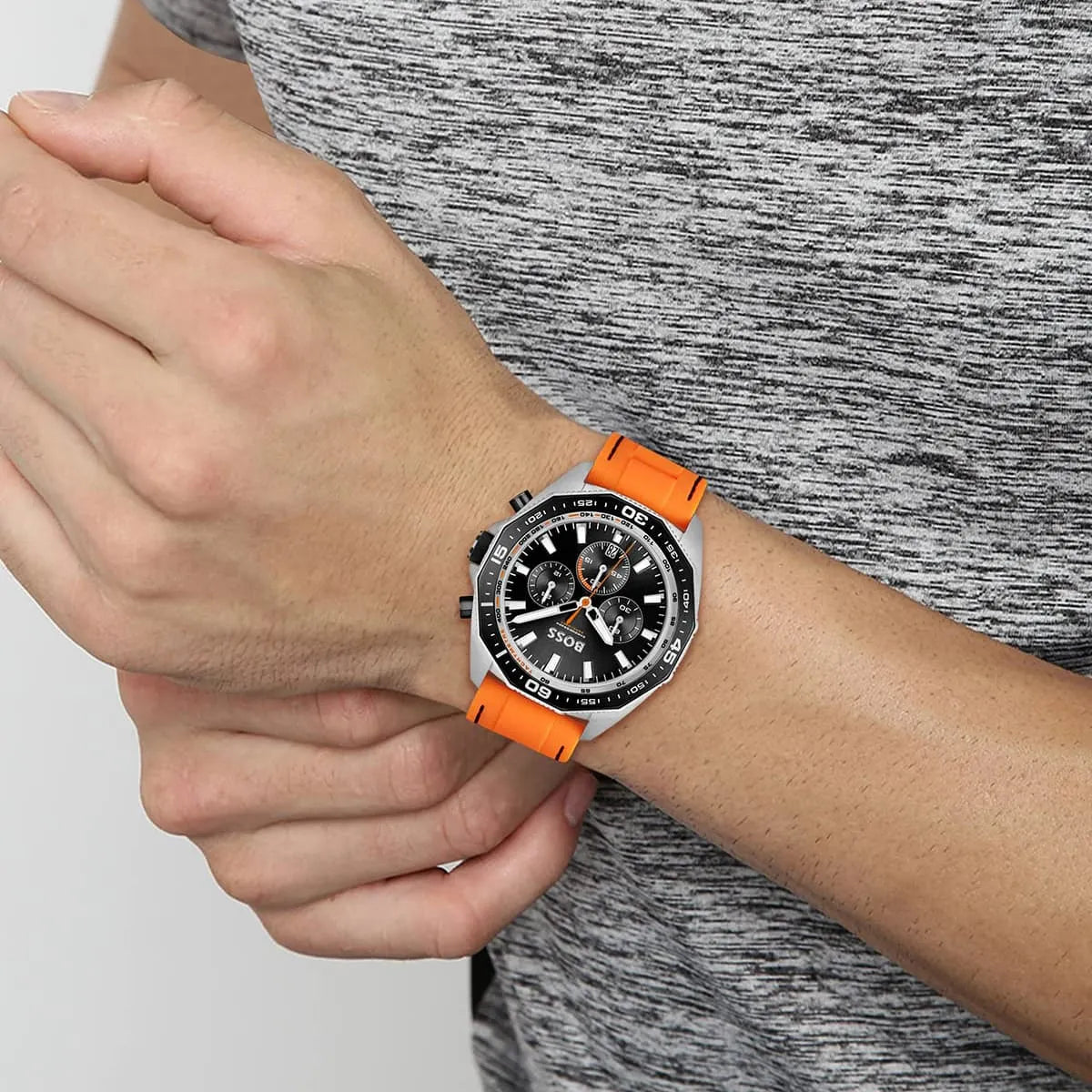 Hugo Boss Energy chronograph watch on wrist displaying black dial and orange rubber strap