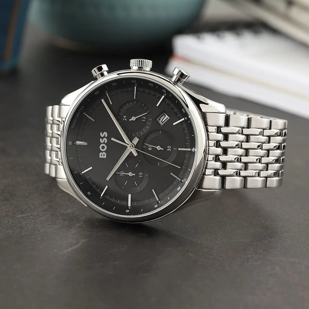 Hugo Boss Gregor chronograph watch on surface showing black dial and steel bracelet