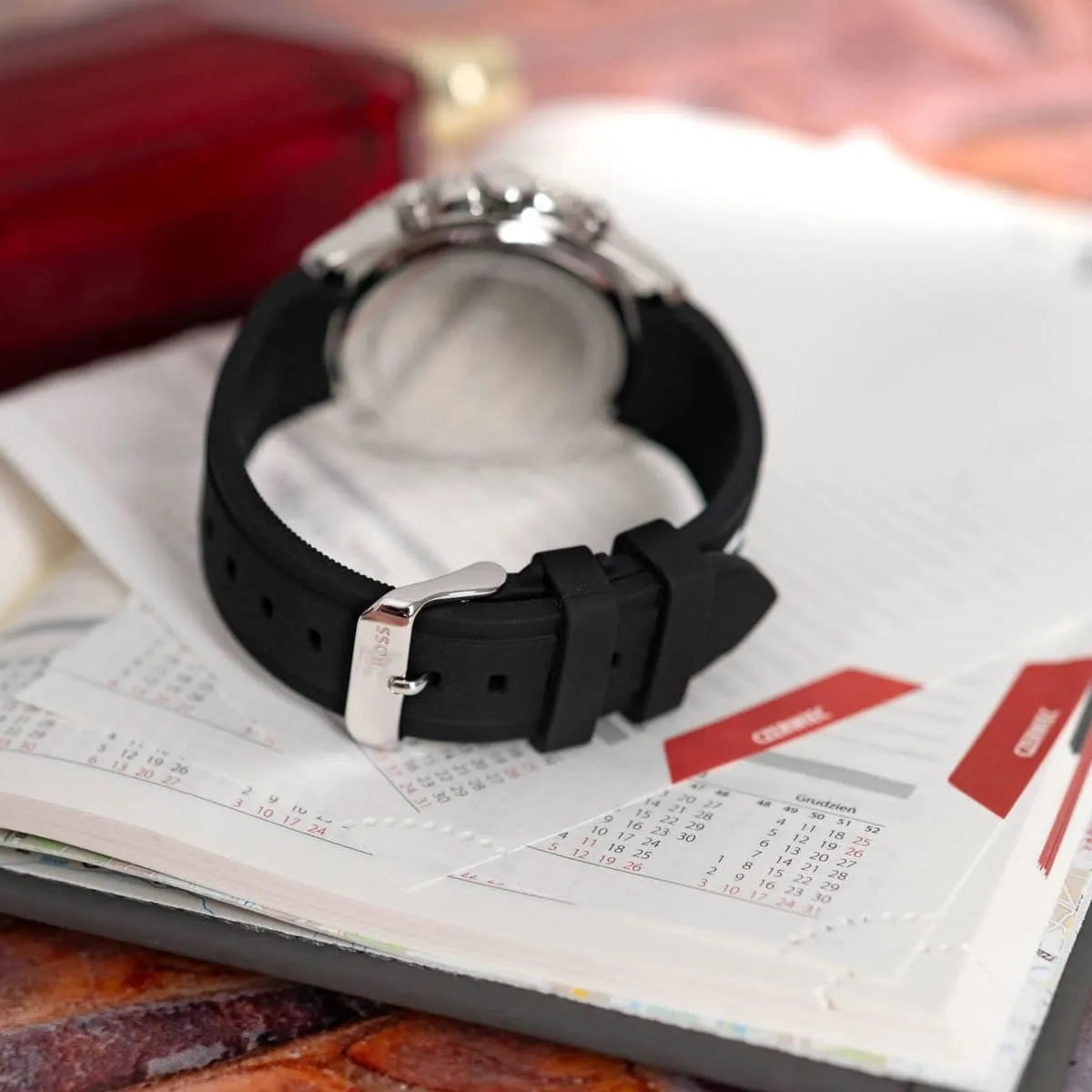 Hugo Boss Runner watch on wrist over newspaper showing black dial and rubber strap