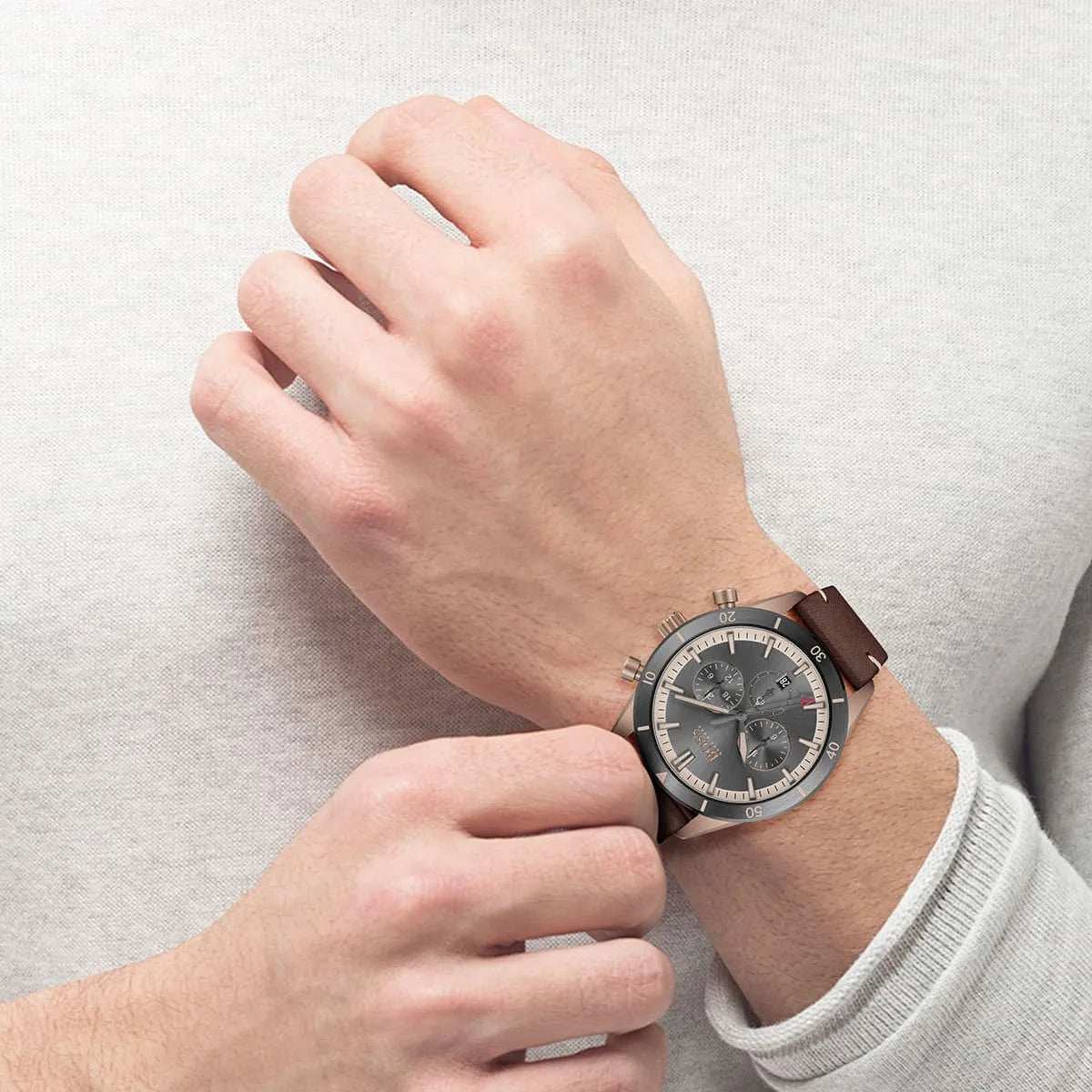 Hugo Boss Santiago chronograph watch on male wrist displaying grey dial and leather strap