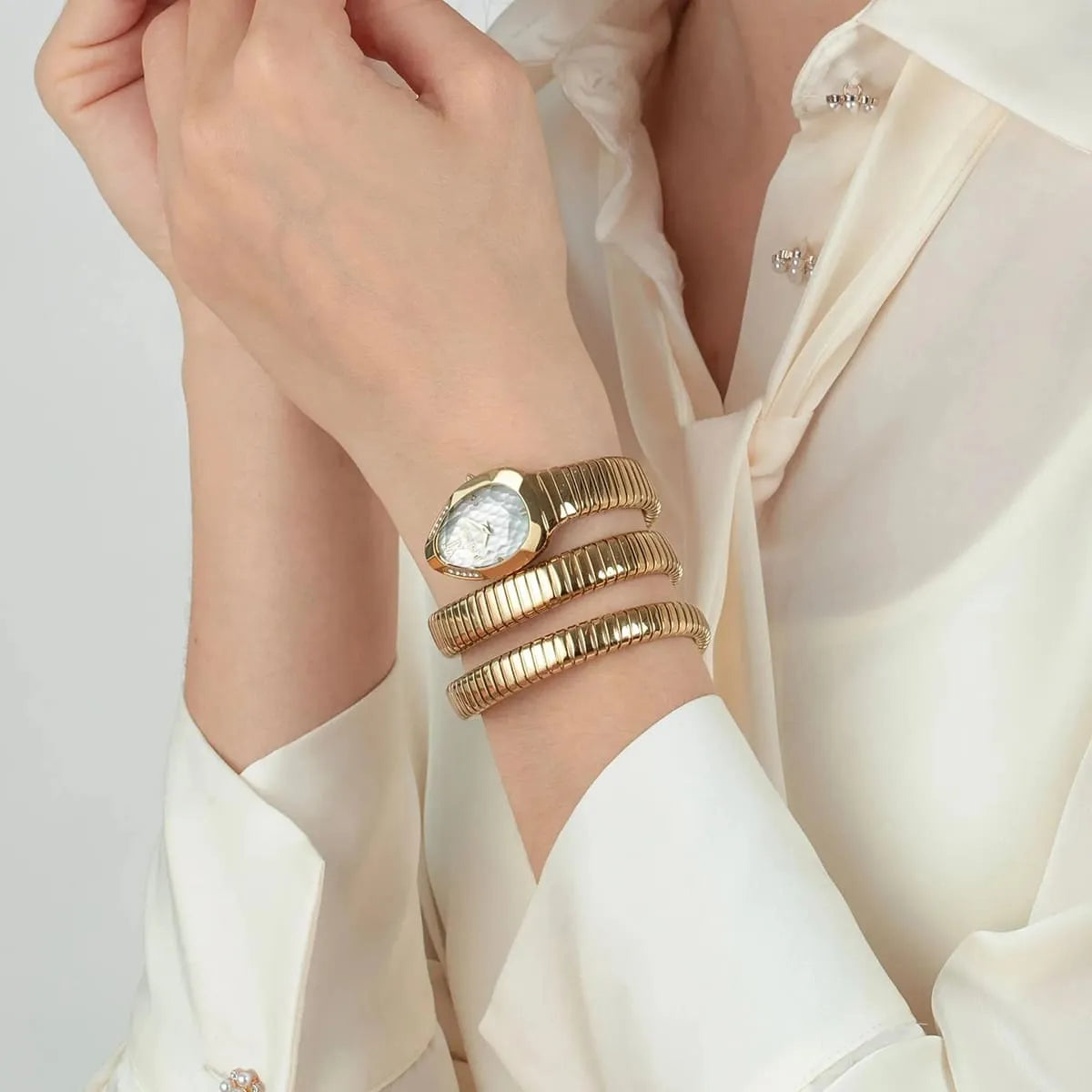 Just Cavalli Snake gold watch worn on wrist with triple-wrap snake strap