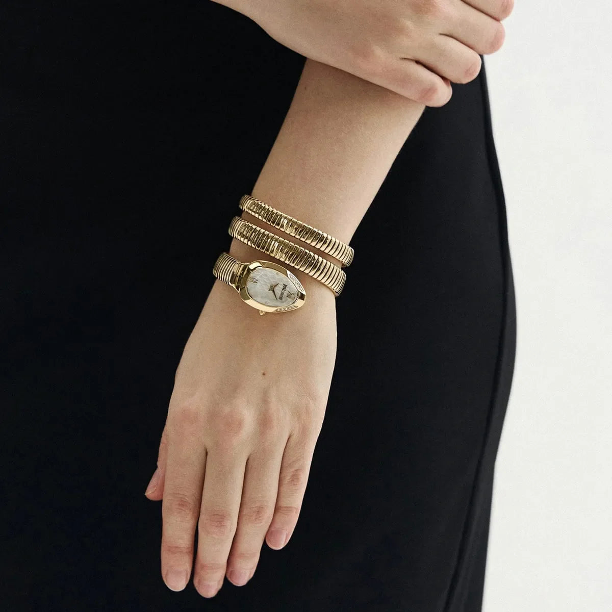 Just Cavalli Snake gold watch on wrist with black outfit styling