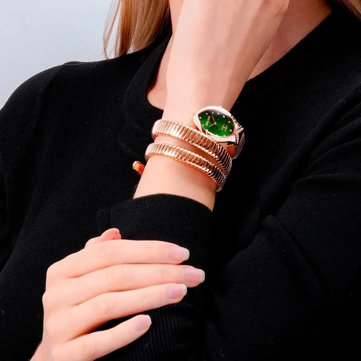 Just Cavalli Snake watch worn on wrist with rose gold triple-wrap bracelet and green dial