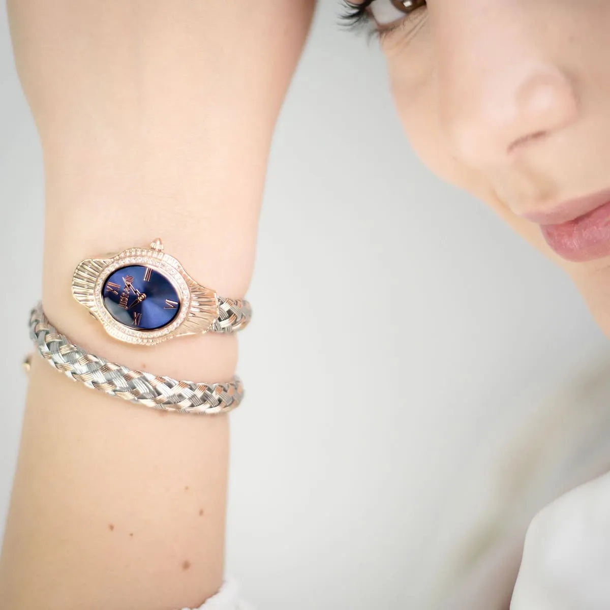 Just Cavalli Signature Snake women's watch worn on wrist with dark blue dial and crystal-set bezel detail