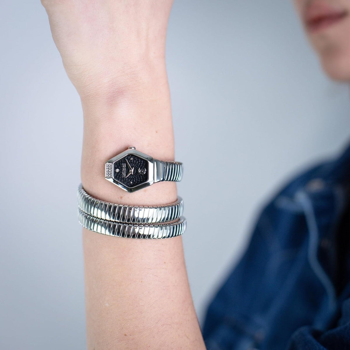 Just Cavalli Romina watch worn on wrist with silver ribbed bracelet and black dial