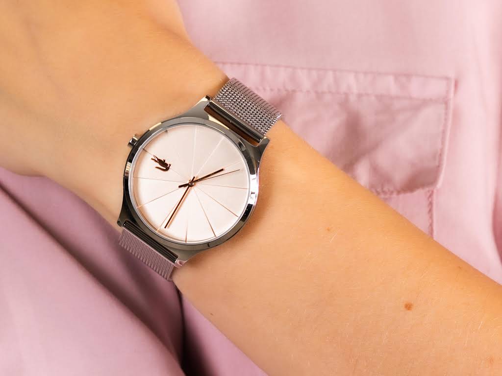 Lacoste 2001042 quartz watch on wrist showing minimalist peach and white dial design