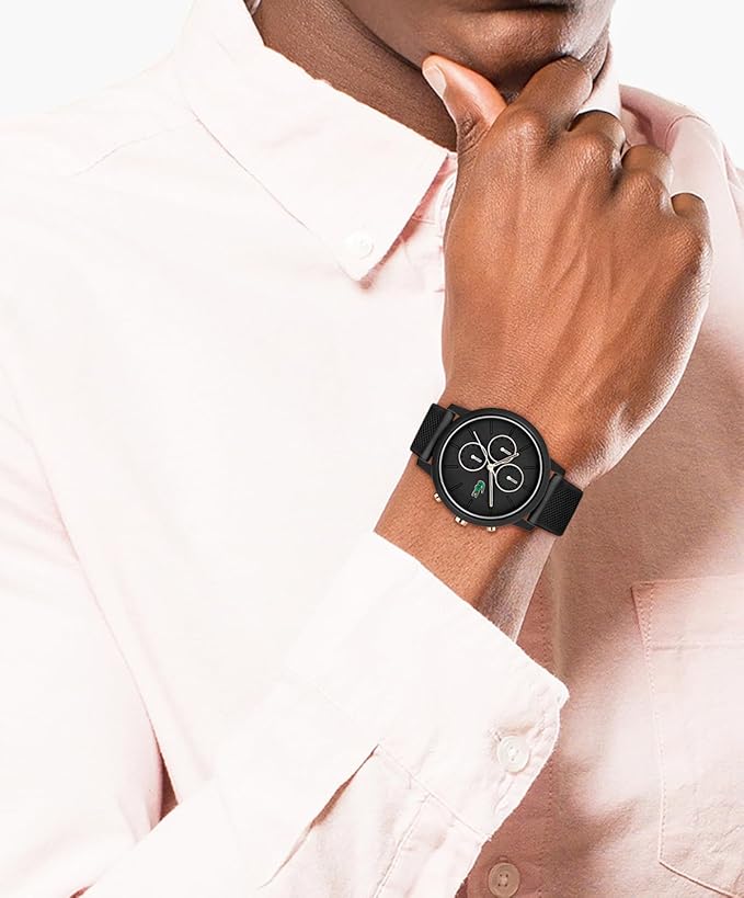 Lacoste black chronograph watch worn on wrist with pink shirt