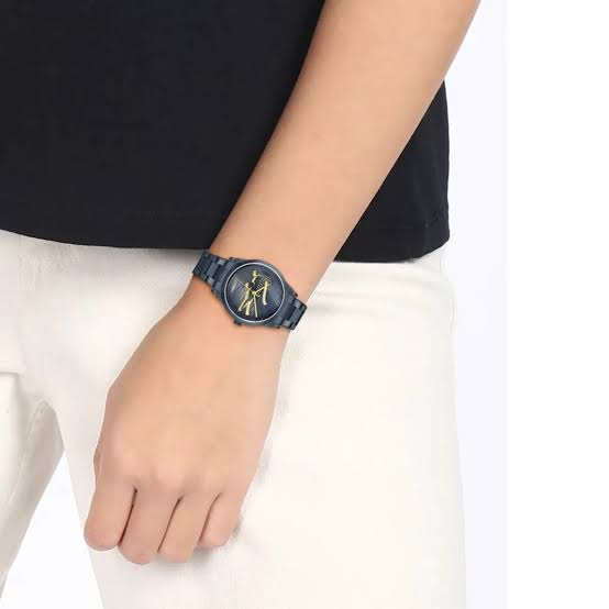 Lacoste LADYCROC MINI watch worn on wrist showing gold crocodile dial and navy bracelet