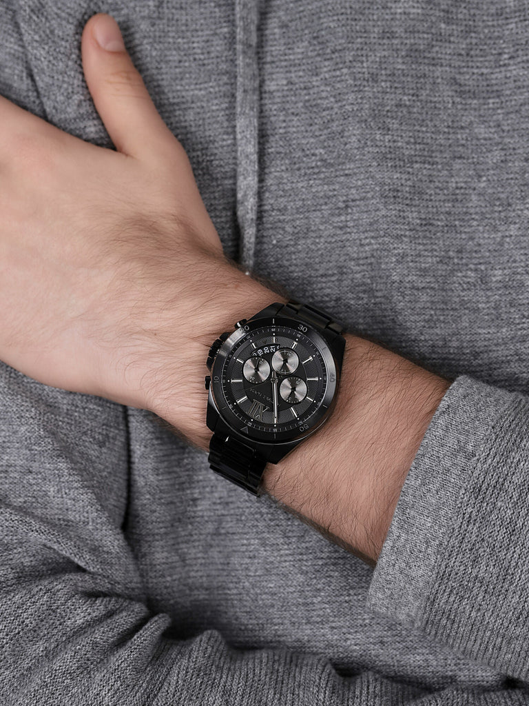 Michael Kors Brecken chronograph watch worn on wrist with gray sweater