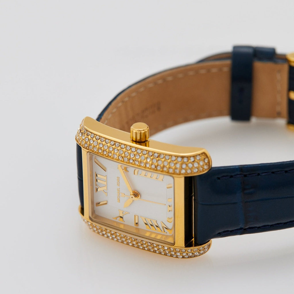 Michael Kors Emery watch angled view showing gold pavé case and navy leather strap
