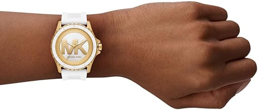 Michael Kors Oversized Everest gold-tone watch on wrist with white silicone strap