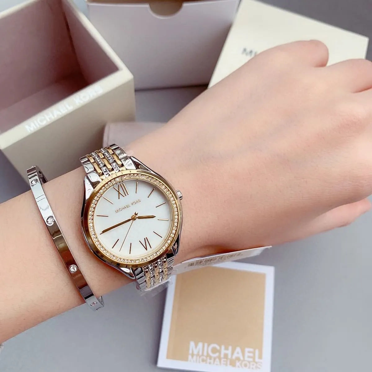 Michael Kors Mindy MK7084 on wrist with Michael Kors box, crystal bezel visible