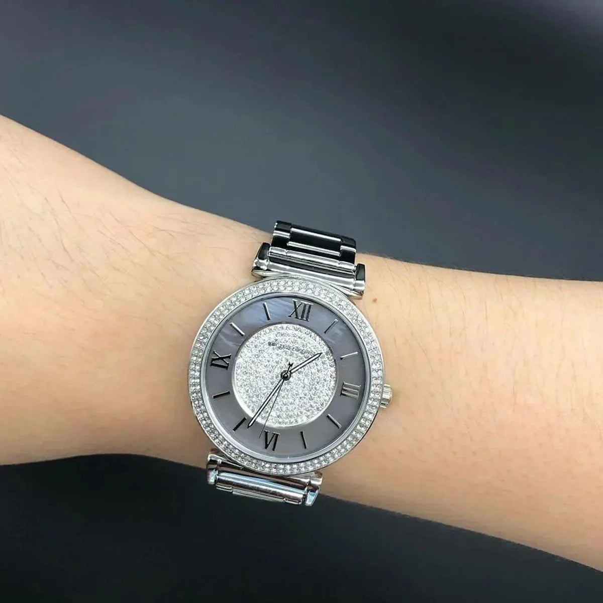 Michael Kors MK3331 watch worn on wrist with stainless steel and black ceramic bracelet