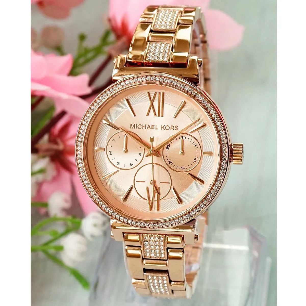 Michael Kors MK4354 Sofie rose gold watch on wrist with pink flowers in background