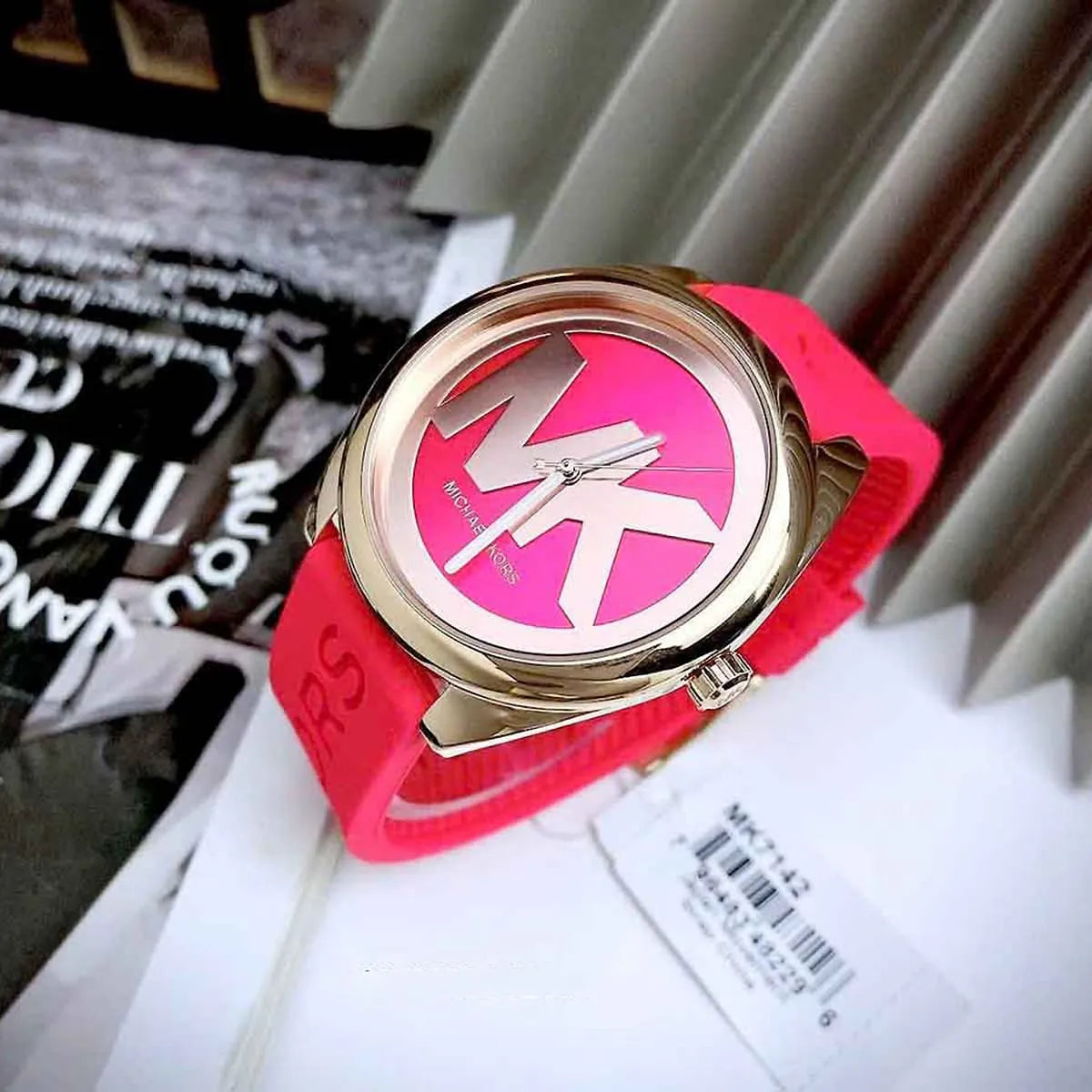 Michael Kors Janelle women's watch on wrist displaying red dial with white MK logo