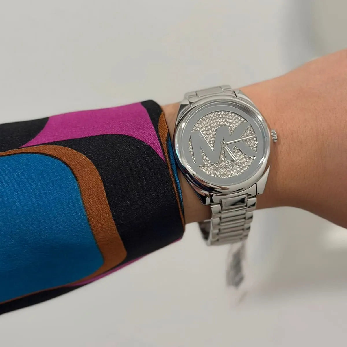 Michael Kors Janelle watch on wrist showing silver dial with crystal detailing and metal bracelet