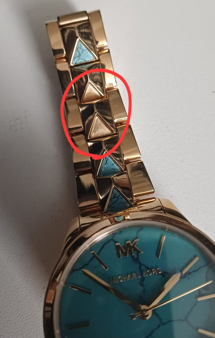 Michael Kors Runway Mercer watch detail showing defect in turquoise triangle link