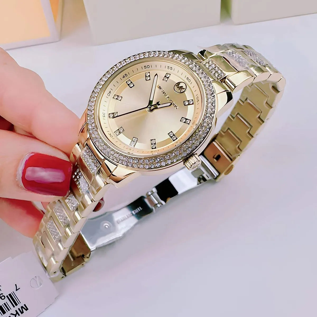 Michael Kors Tibby MK4575 gold watch worn on wrist with crystal-embellished bracelet