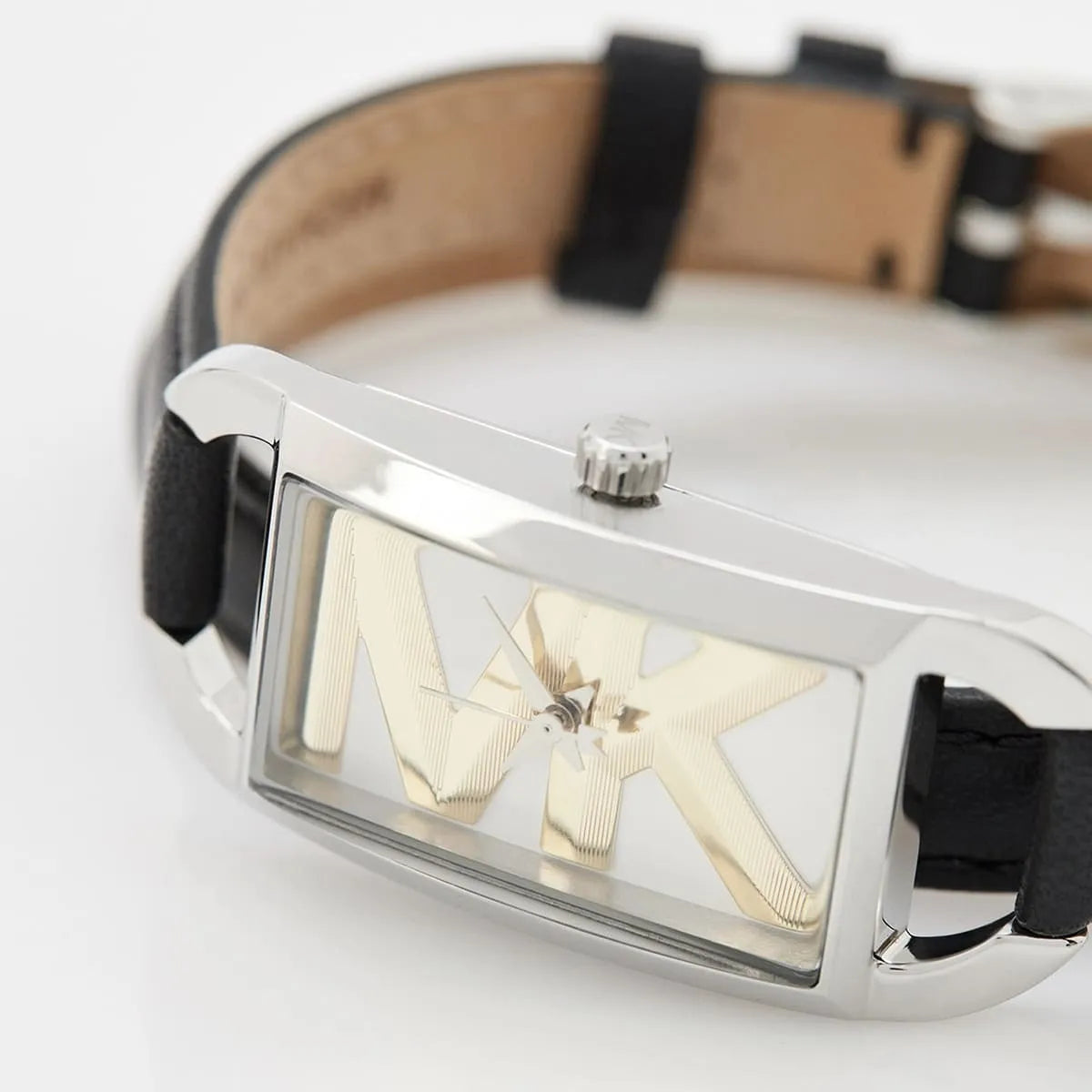Close-up of Mini Empire dial showing gold geometric X design, silver indices, and crown on silver rectangular case