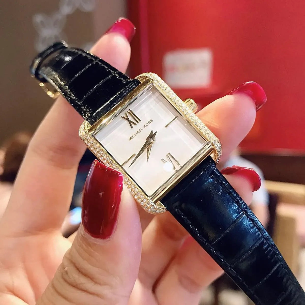 Michael Kors Lake MK2762 worn on wrist displaying crystal-studded square case and white dial face