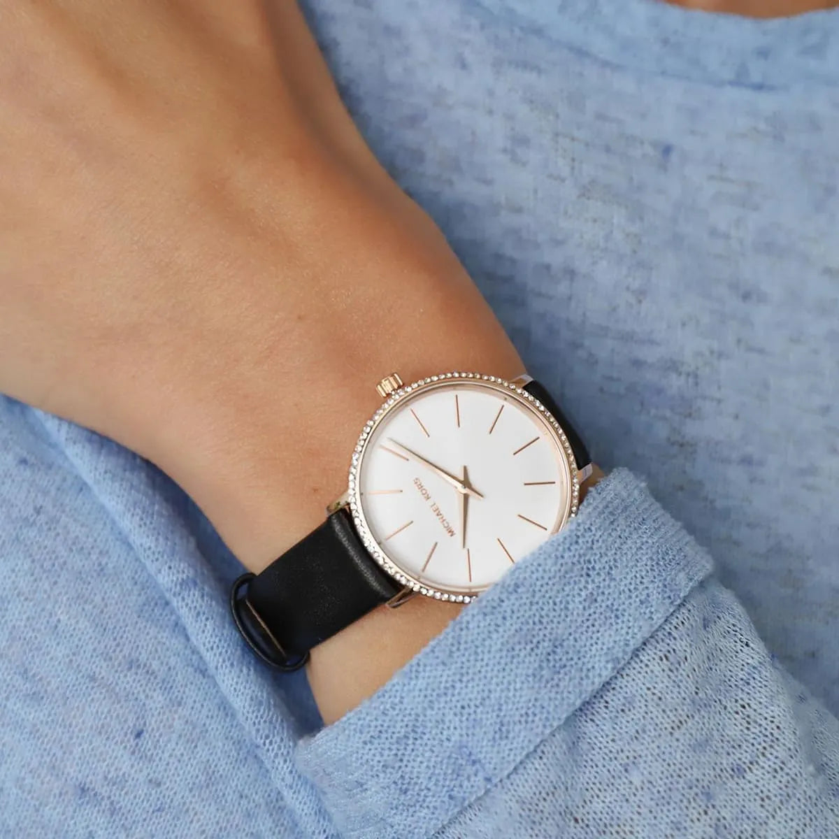 Michael Kors Pyper watch worn on wrist showing white dial and black leather strap
