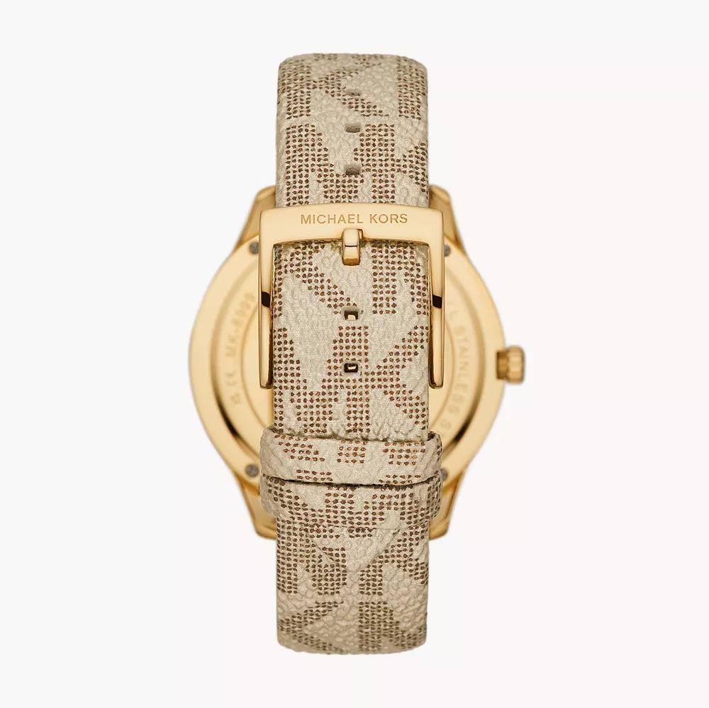 Angled view of Michael Kors Mini Jaycie gold watch with beige patterned canvas strap