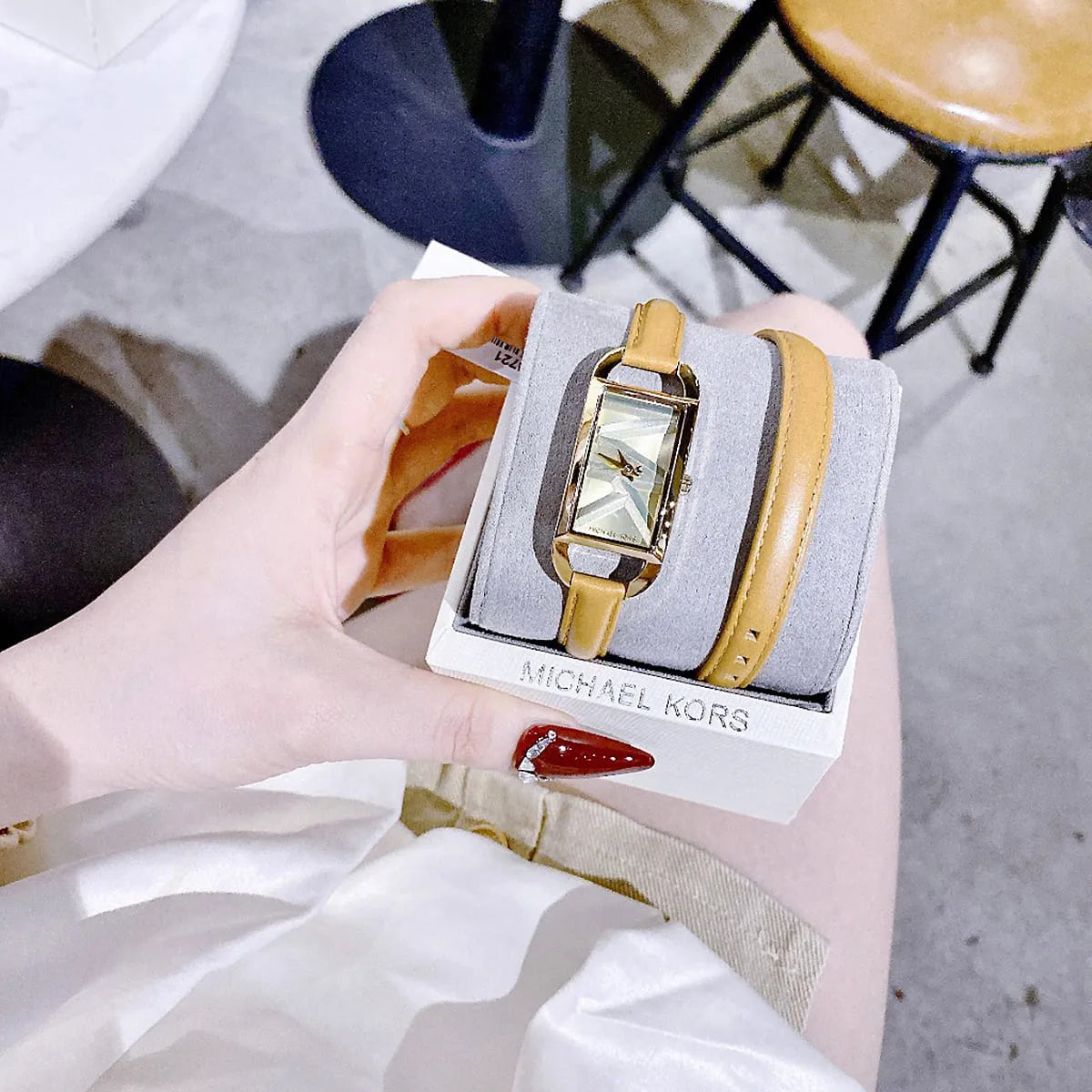 Michael Kors Empire watch displayed with accessories on branded packaging