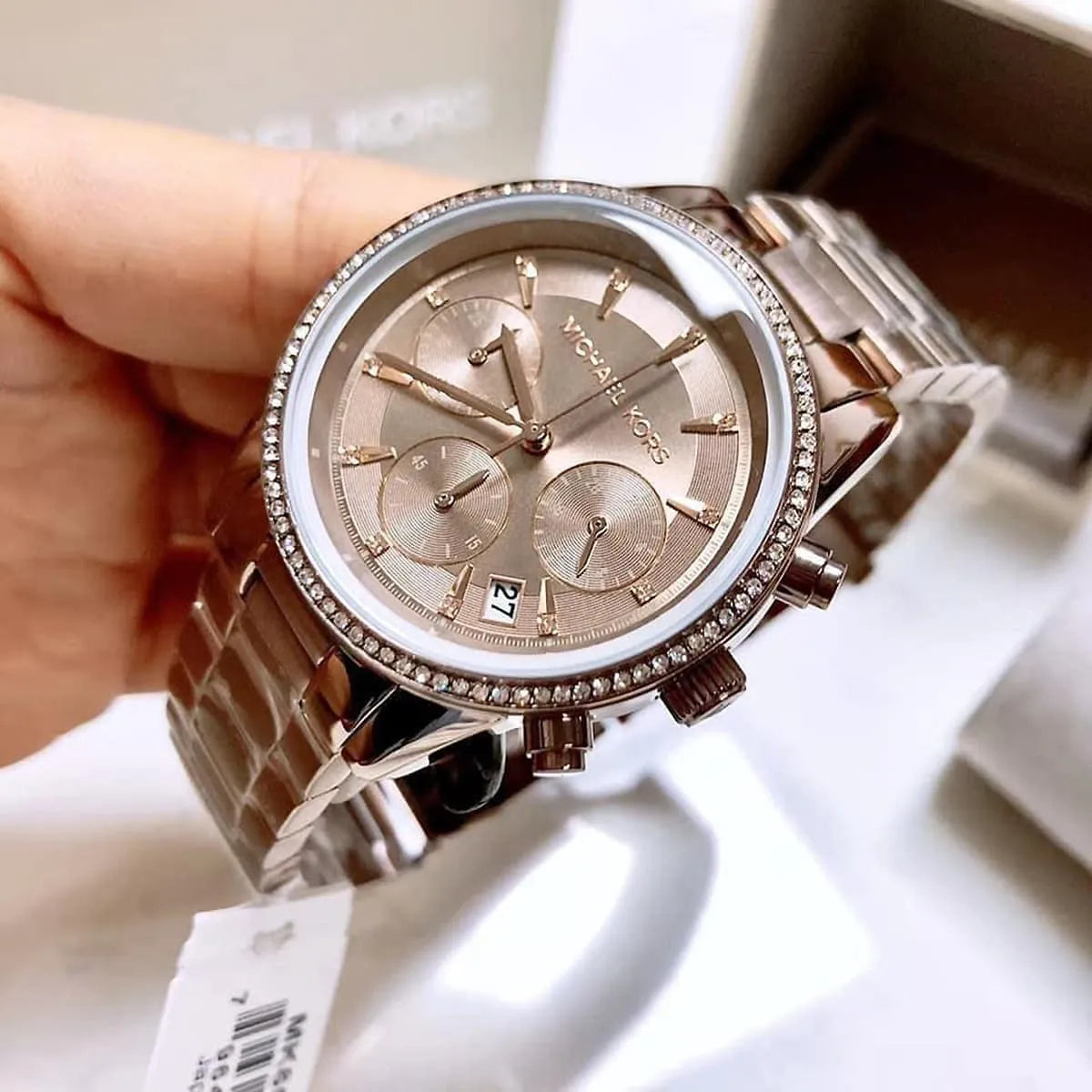 Michael Kors Ritz chronograph watch held in hand showing full dial and crystal bezel detail