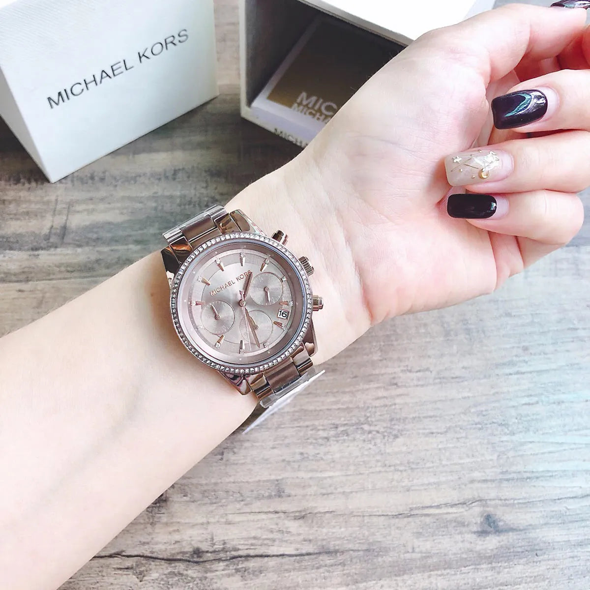 Michael Kors Ritz chronograph watch displayed on wrist with packaging in background