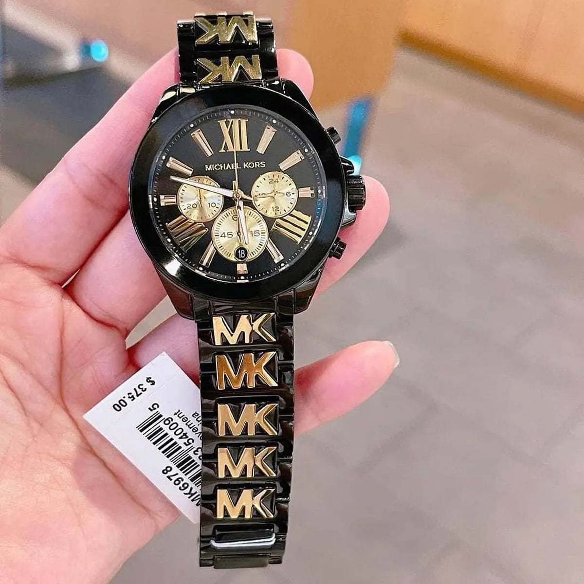Michael Kors Wren MK6978 watch held in hand showing full view of chronograph timepiece