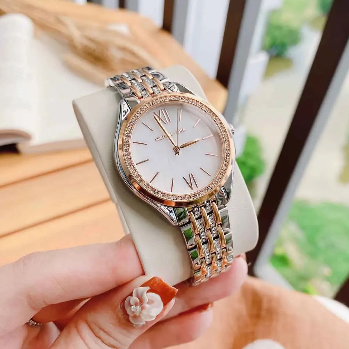 Mindy watch displayed on hand with two-tone stainless steel strap and crystal-adorned rose gold bezel