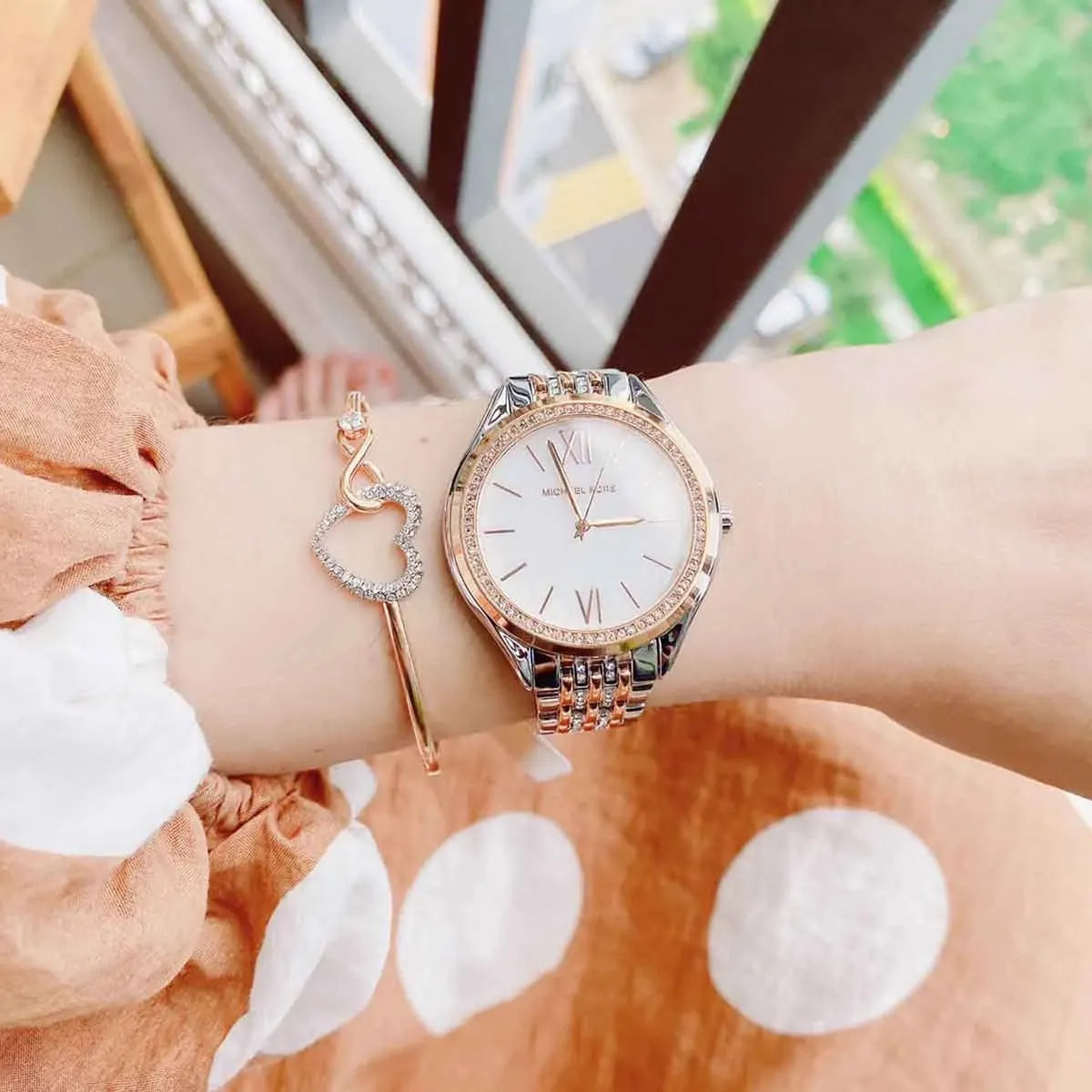 Mindy watch worn on wrist, displaying white dial with Roman numerals and crystal bezel