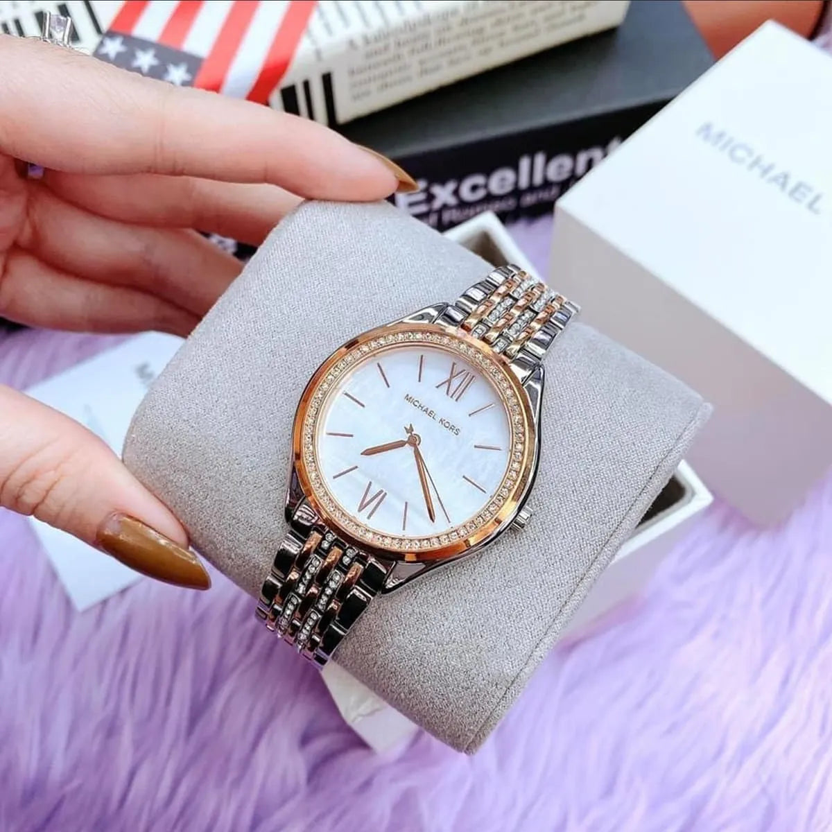 Mindy watch on decorative stand showing full view of white dial, rose gold bezel, and two-tone bracelet