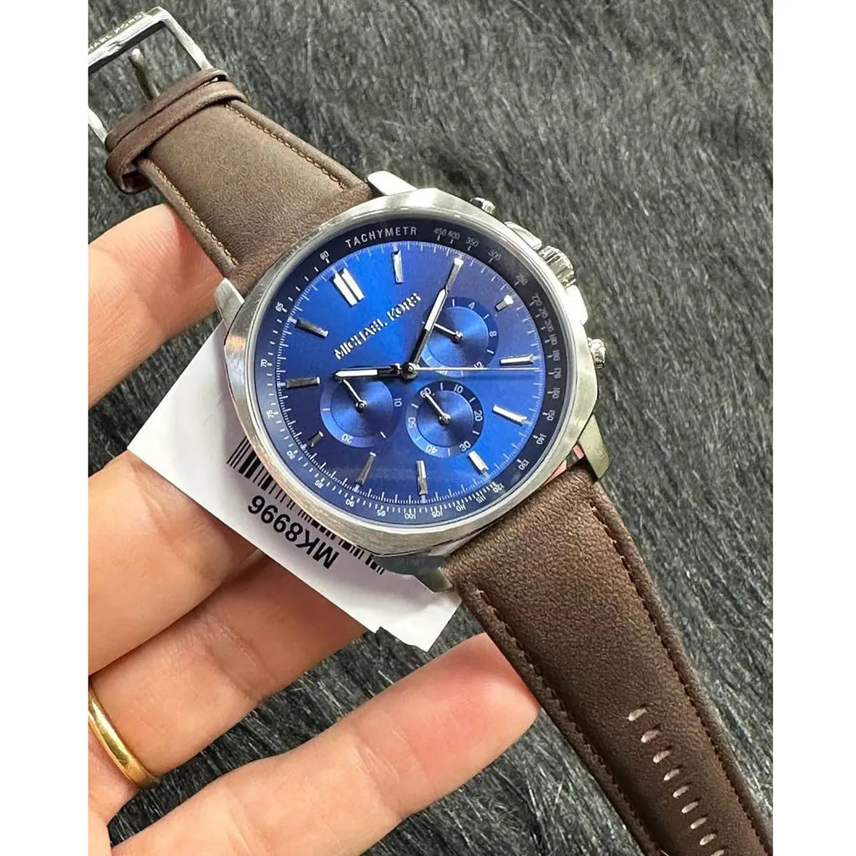 Michael Kors MK8996 chronograph watch on wrist with blue dial and brown leather strap