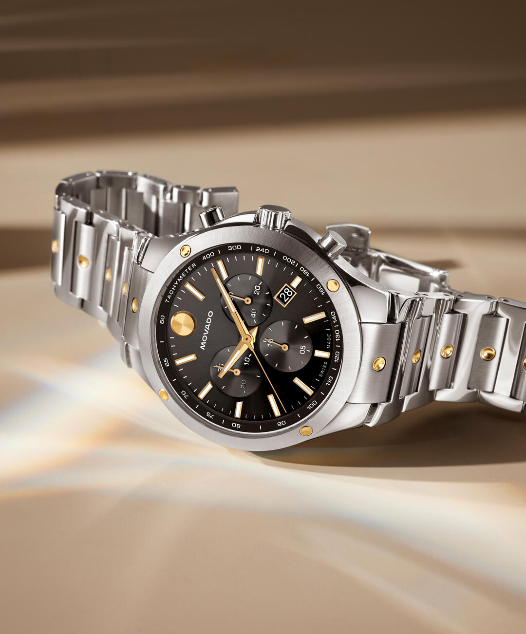 Movado chronograph timepiece on neutral background showing full case and bracelet detail