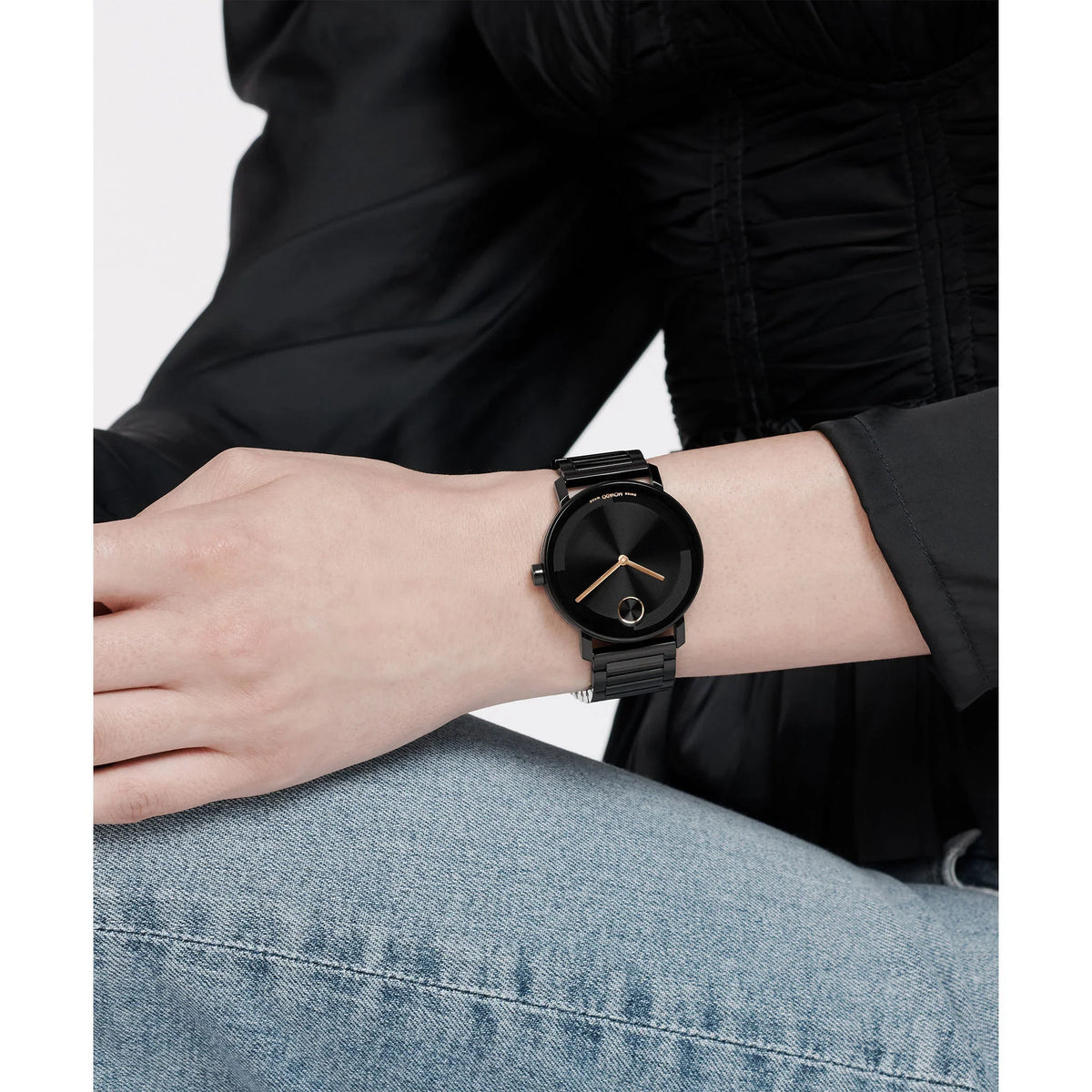 Movado black steel watch worn on wrist with black dial and rose gold accents