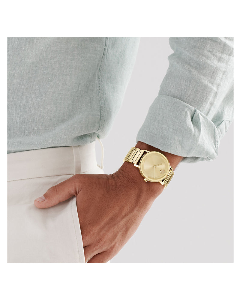 Movado Bold Evolution 2.0 goldtone watch worn on wrist with light blue dress shirt