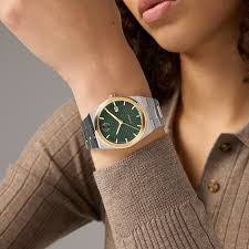 Movado BOLD Quest automatic watch worn on wrist with green dial and gold-tone bezel
