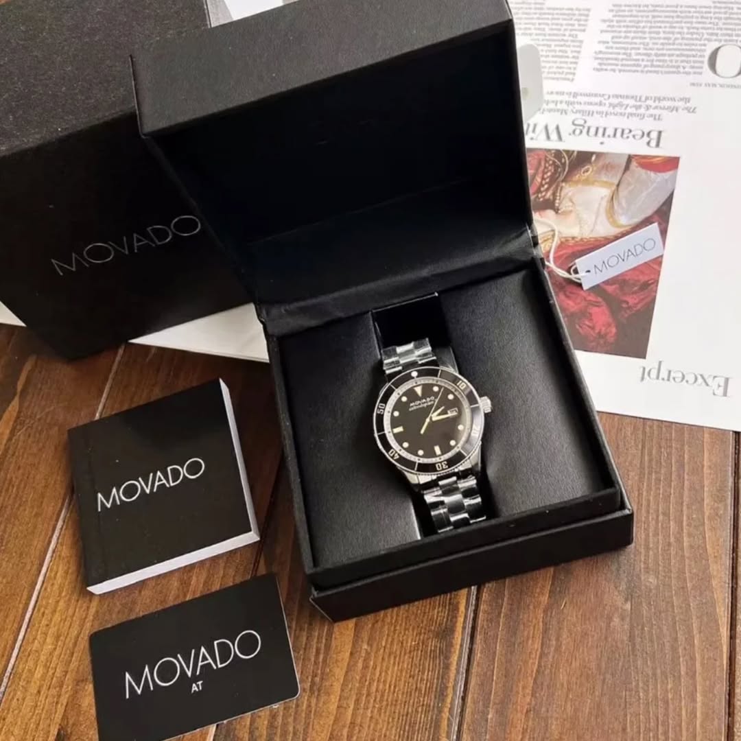 Movado Heritage men's watch unboxing display with black branded box, watch, and accessories