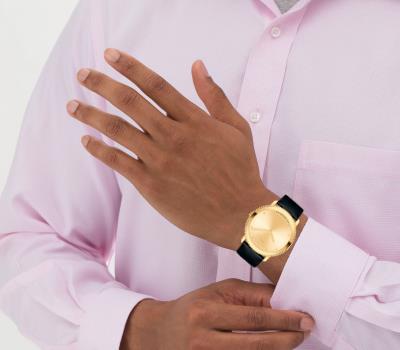 Movado Sapphire gold watch worn on wrist with black leather strap
