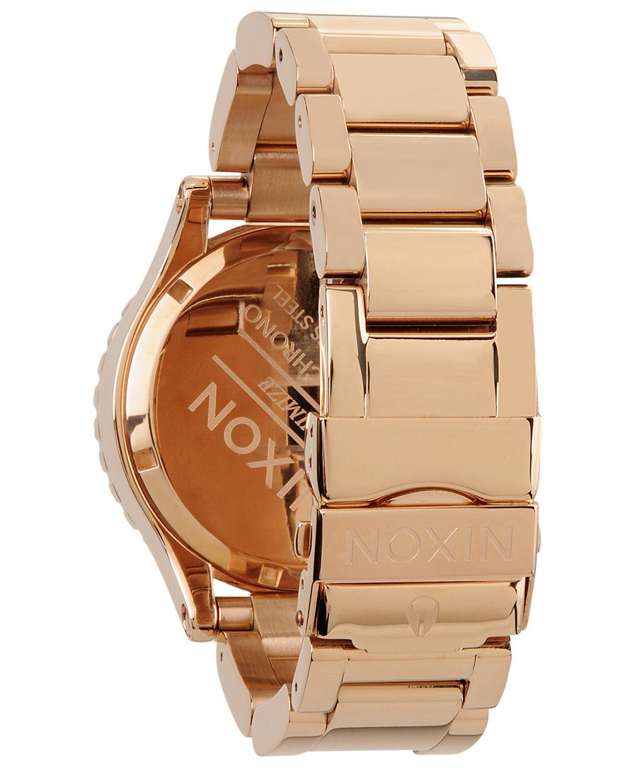 Angled view of Nixon 42-20 watch displaying rose gold-tone three-link bracelet and case profile