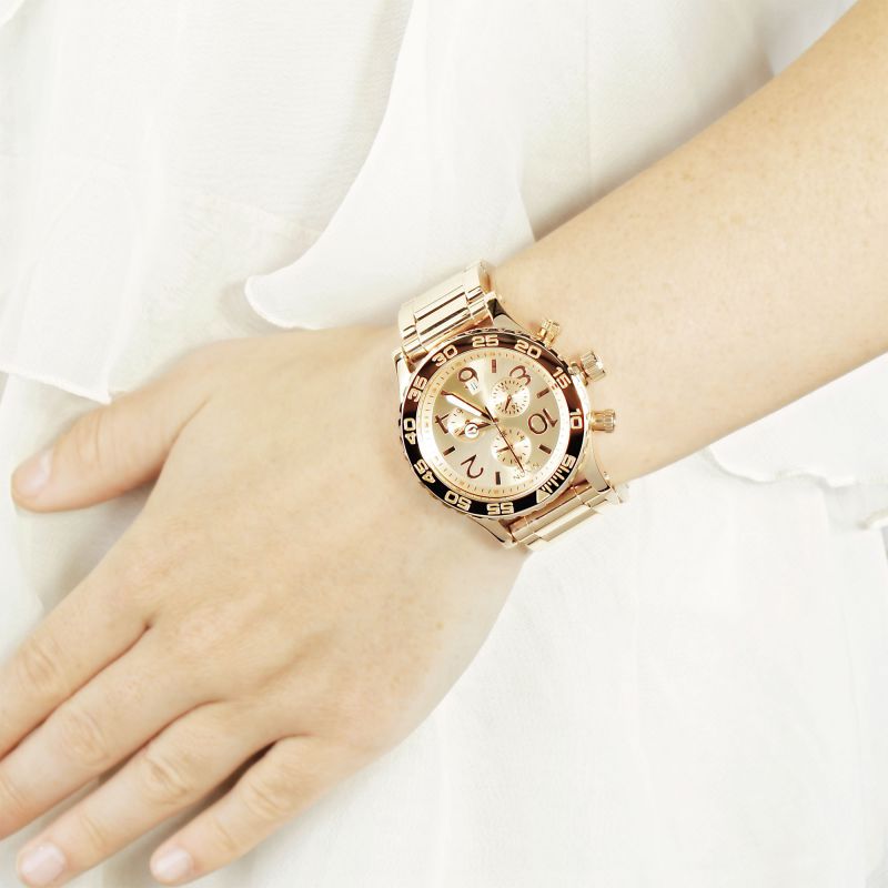 Nixon 42-20 chronograph watch worn on wrist, showing rose gold-tone case and bracelet with dial