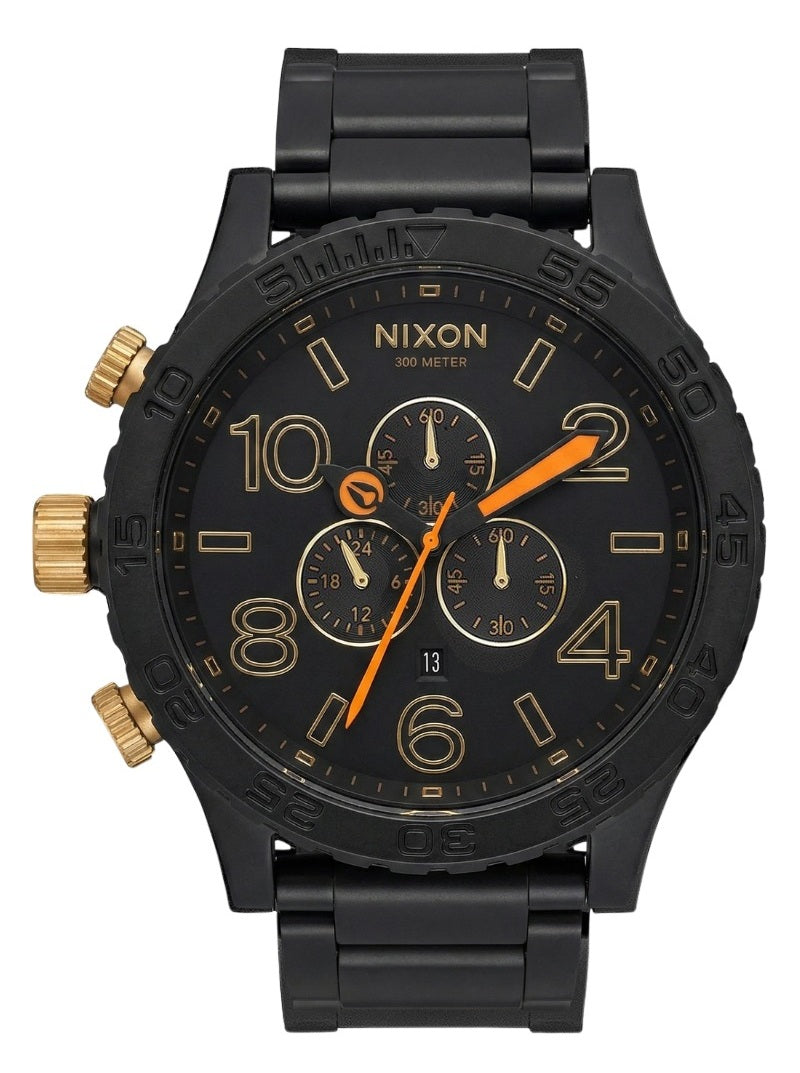 Nixon 51-30 chronograph watch with matte black case, gold accents, and orange hands on black dial