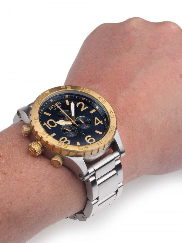 Nixon 51-30 Chrono chronograph watch worn on wrist, showing silver band and gold bezel